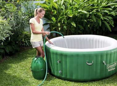 White-Haired woman filling Coleman SaluSpa Inflatable Hot Tub with a hose